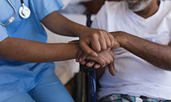 Nurse comforts a patient in a wheelchair